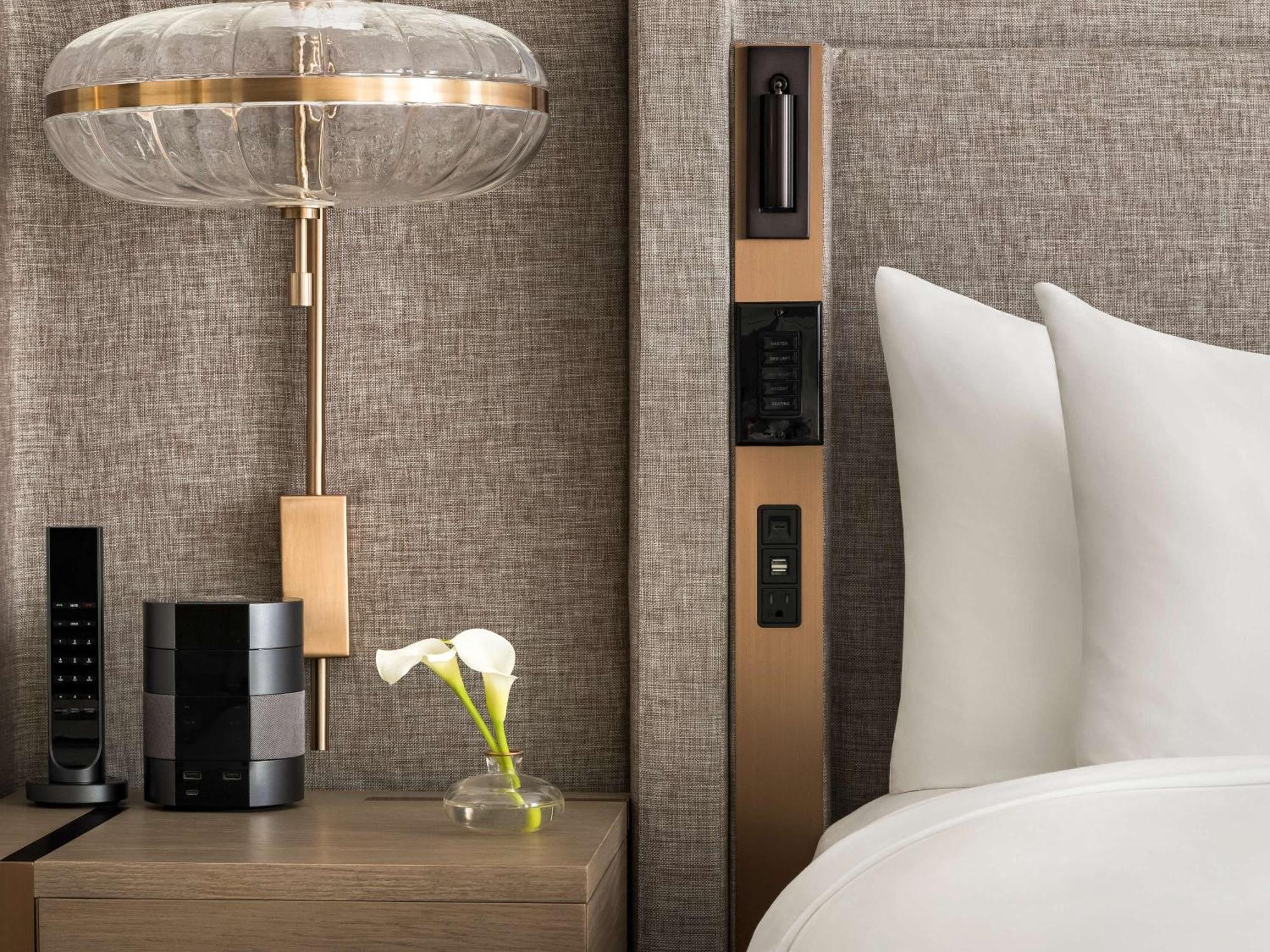 Fairmont Chateau Lake Louise Bagian luar foto A bedside table with a phone, a remote control and a flower